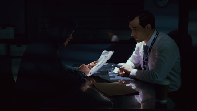  Criminal in handcuffs being interrogated by police detective
