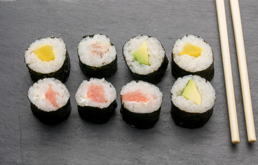 Tasty sushi roll with wooden chopsticks, closeup. Food Concept