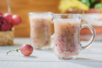 Grape smoothie over the white table.