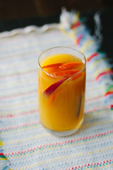 Mango and orange smoothie in transparent glass.