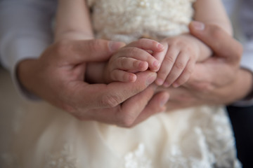 Father holds the hands of his daughter in his hands