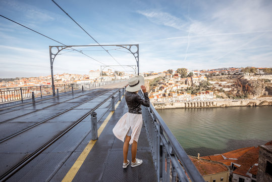 View on the Luis bridge with young woman walking back during the sunny weather in Porto city, Portugal