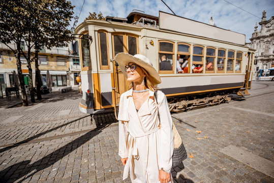 Lifestyle portrait of a woman near the famous old touristic tram on the street in Porto city, Portugal