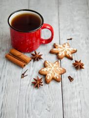Red cup of tea and two snowflakes Christmas cookies on the grey wooden  table