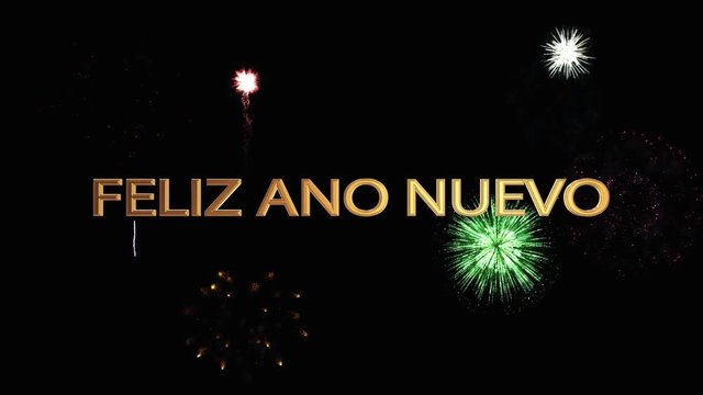 Golden letters happy new year in  Spanish soar into the dark night sky against a bright festive fireworks