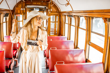 Young and pretty woman having excursion at the old retro touristic tram in Porto city, Portugal