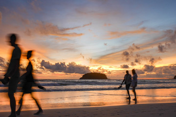 Fototapeta premium blurred people at the beach with twilight cloudy sky.There is an island in the sea