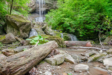 Logs and boulders at the foot of the waterfall.