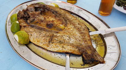 mullet - open roasted fish lemon dish - food of west Greece called 