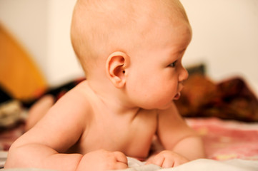 Caucasian boy lies on the bed. Children's emotions.