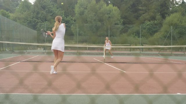  Female tennis players enjoying a game on outdoor court in the summer