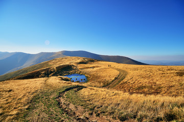 Mountain bikers riding the mountain bikes on the trail to horizon line against beautiful fall mountain landscape.  Extreme sport concept.