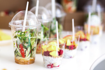 Mini desserts and healthy vegetable microgreen salads in plastic cups canaps. Catering served table