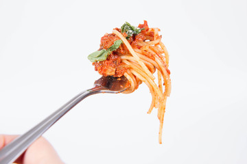 Spaghetti bolognese on a fork on a white background