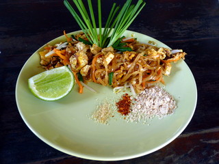 Thai food on plate noodles Pat Thai decorated with lime and leafs