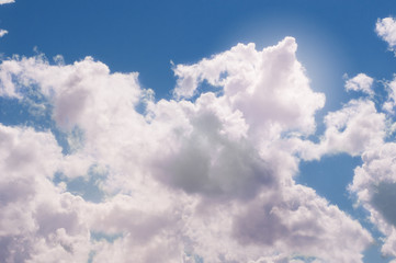 Naklejka na ściany i meble White cumulus fluffy clouds on a blue sky.
