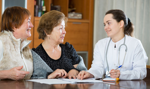 Female therapeutist consulting senior patients in clinic