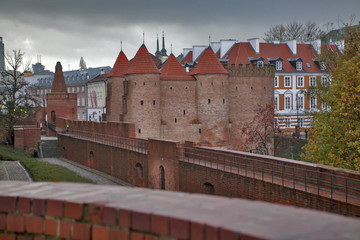 Fototapeta na wymiar Walls and towers of the Warsaw barbican, between the Old and New Town. The major tourist attraction