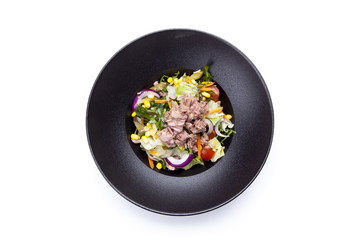 Fresh salad with tuna, tomatoes, eggs, arugula and mustard on white textured background top view. Healthy food.