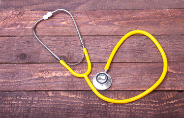 Medical stethoscope and tablets isolated on wooden background