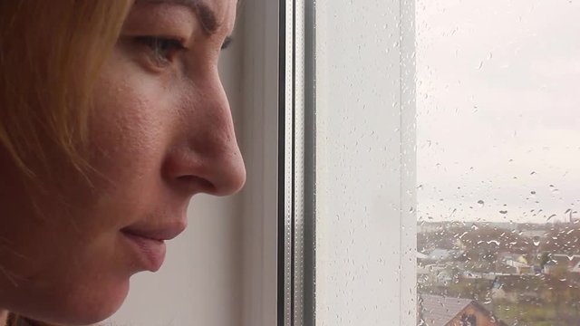 Girl looking out of window a rainy day