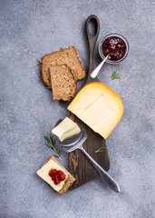Delicious dutch gouda cheese with cheese slices, multigrain bread, strawberry jam and special knife...