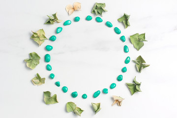 A frame of dried flowers of hydrangeas and turquoise pebbles. marble background. Top view, flat lay