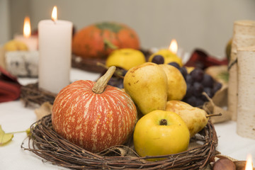 Autumn arrangement with tasty pears,quince, pumpkins and candles.