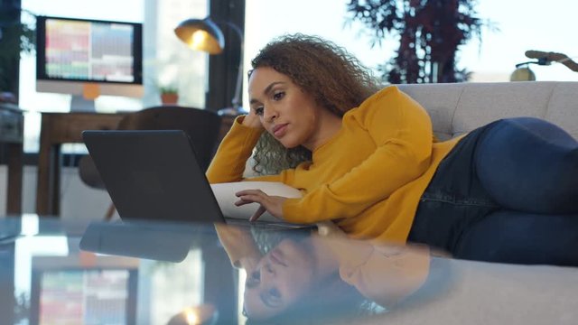  Beautiful woman relaxing at home & working on laptop computer