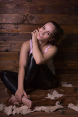Fototapeta na wymiar Happy blonde model with natural makeup, wears pink shirt, posing on a brown wood background