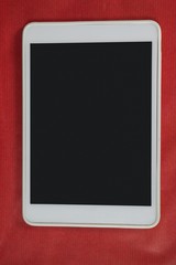 Digital tablet on red background