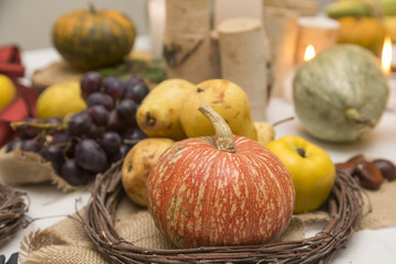 Naklejka na ściany i meble Autumn arrangement with tasty pears,quince, pumpkins and candles.