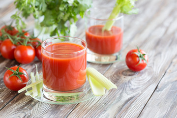 Tomato juice in a glass with celery and tomatoes
