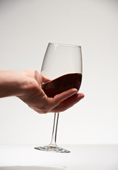 Red wine glass in hand palm