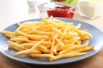 Plate with yummy french fries on table