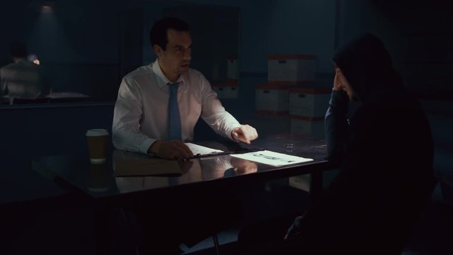  Police detective in interview room interrogating a suspect