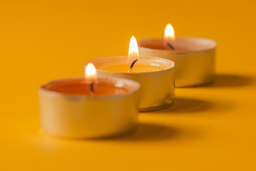 Obraz na płótnie Canvas Drei brennende Teelichte mit weichem Hintergrund