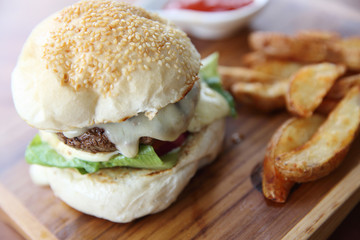 Beef hamburger with cheese and fires on wood background