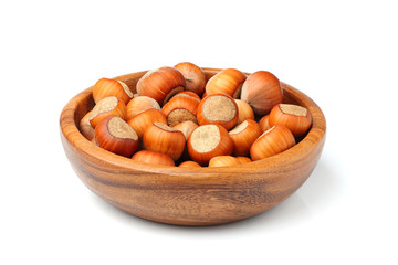 Hazelnuts in wooden bowl isolated.
