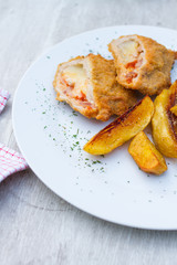 baked potato and slice of veal or other light meat, coated in breadcrumbs and fried
