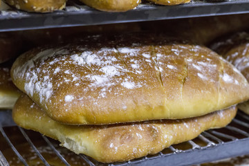 Many ready-made fresh bread in a bakery oven in a bakery. Bread making business. Soft focus