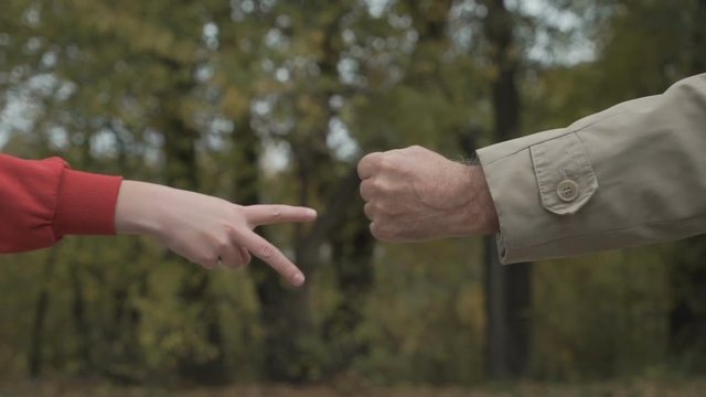 Grandfather and grandson plays in rock, paper, scissors