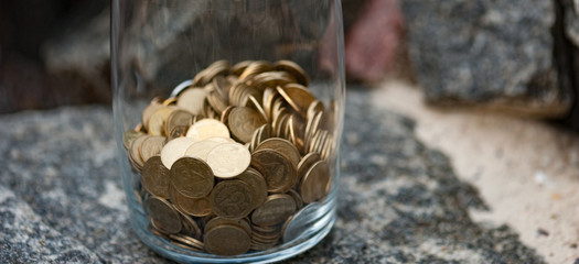 The panorama of  bottle money with coins standing in the stone. Saving and protect money concept