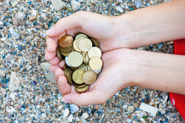  Handful of coins in palm female hands. Concept of saving and passive income