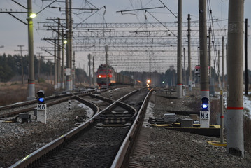 Fototapeta na wymiar Railway crossroad in the evening, blurred trains at background.