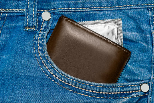 wallet in a pocket of blue jeans with silver condom