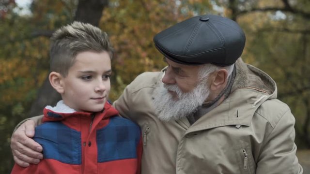 Grandfather talks with grandson and embraces him