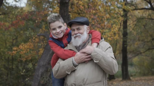 Portrait of grandson embraces grandfather