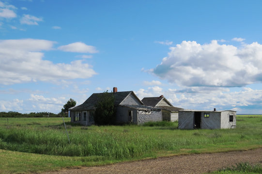 Many old houses and a storage unit in the middle of a field in Saskatchewan, Canada.