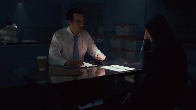  Police detective in interview room interrogating a suspect